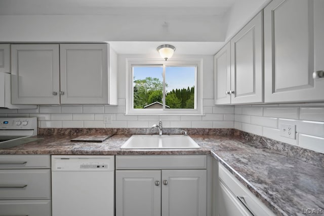5662 Caren Dr, Ypsilanti, MI 48197 - kitchen with white appliances, a sink, decorative backsplash, and dark countertops