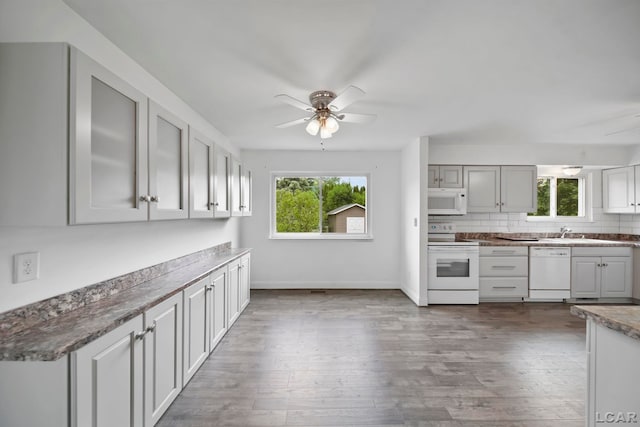 5662 Caren Dr, Ypsilanti, MI 48197 - kitchen with white appliances, ceiling fan, plenty of natural light, and dark wood-style flooring