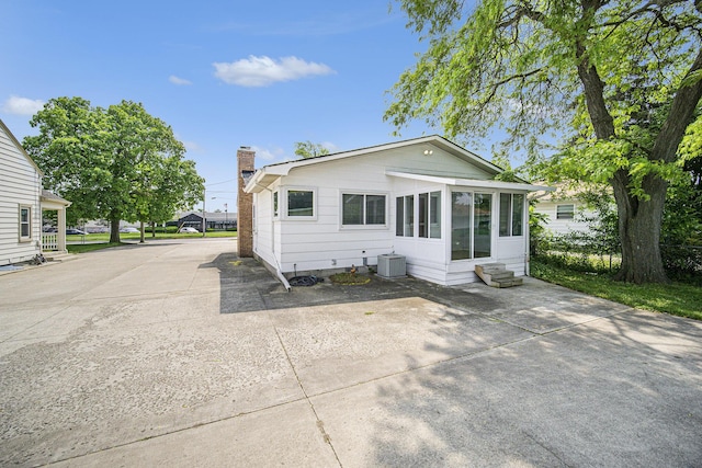 111 N Maple Rd, Saline, MI 48176 - view of front facade with a chimney, cooling unit, a sunroom, and entry steps