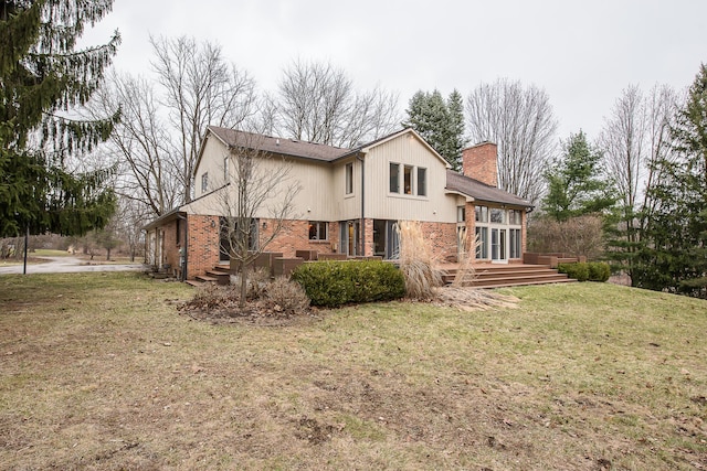 3329 Craig Rd, Ann Arbor, MI 48103 - back of property with a chimney, a lawn, brick siding, and a wooden deck