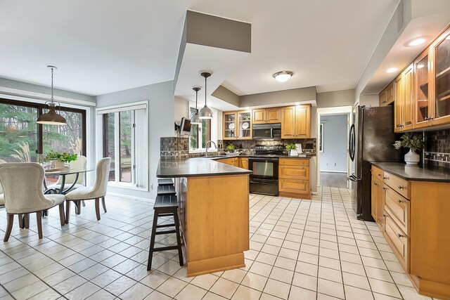 3329 Craig Rd, Ann Arbor, MI 48103 - kitchen featuring black / electric stove, dark countertops, a peninsula, and light tile patterned flooring