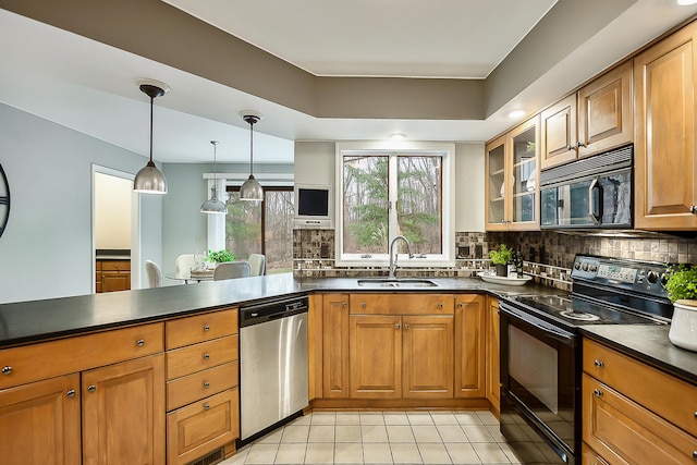 3329 Craig Rd, Ann Arbor, MI 48103 - kitchen with black appliances, a sink, brown cabinetry, dark countertops, and decorative backsplash