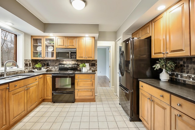 3329 Craig Rd, Ann Arbor, MI 48103 - kitchen with black appliances, a sink, dark countertops, backsplash, and light tile patterned floors