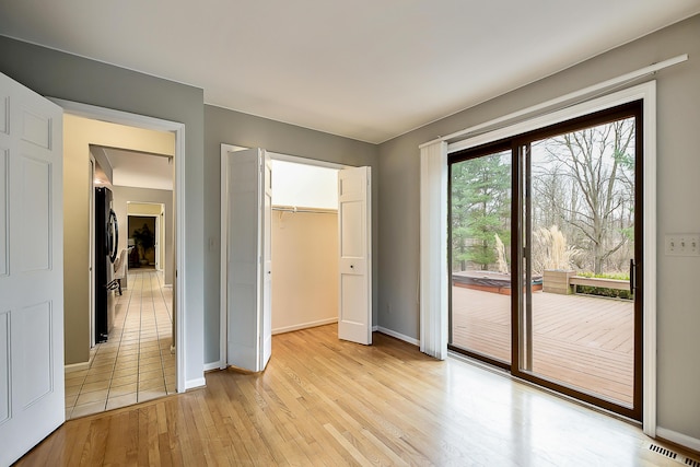 3329 Craig Rd, Ann Arbor, MI 48103 - unfurnished bedroom featuring freestanding refrigerator, access to outside, light wood-style floors, baseboards, and a closet