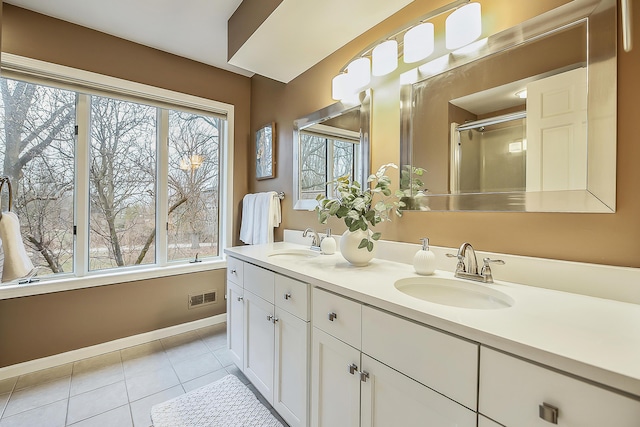 3329 Craig Rd, Ann Arbor, MI 48103 - bathroom with tile patterned floors, double vanity, baseboards, and a shower with shower door