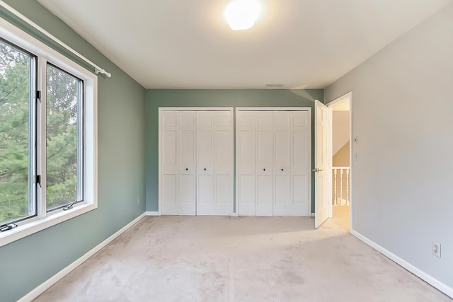 3329 Craig Rd, Ann Arbor, MI 48103 - unfurnished bedroom featuring two closets, carpet flooring, and baseboards