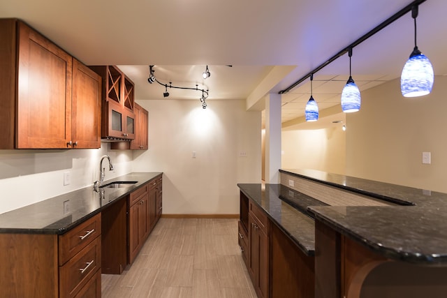 3329 Craig Rd, Ann Arbor, MI 48103 - kitchen featuring a sink, brown cabinets, and dark stone counters