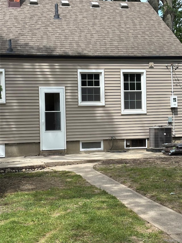 1139 S 7th St, Ann Arbor, MI 48103 - rear view of house with central AC, roof with shingles, and a lawn