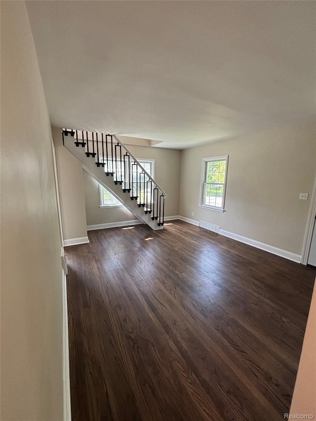 1139 S 7th St, Ann Arbor, MI 48103 - unfurnished living room featuring stairs, dark wood finished floors, and baseboards