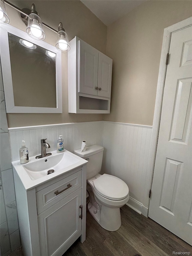 1139 S 7th St, Ann Arbor, MI 48103 - half bath featuring vanity, wood finished floors, wainscoting, and toilet