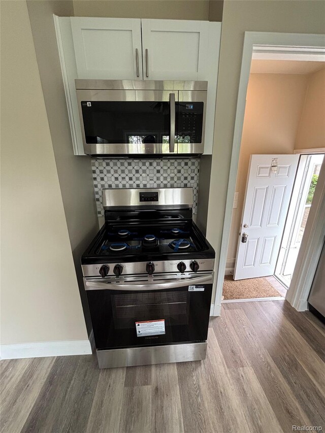 1139 S 7th St, Ann Arbor, MI 48103 - kitchen with stainless steel appliances, light wood-style flooring, and backsplash