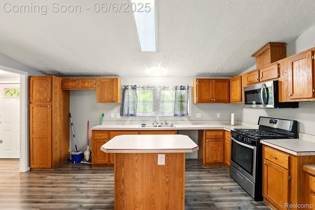 10900 Tuttlehill Rd, Milan, MI 48160 - kitchen featuring stainless steel appliances, dark wood finished floors, a center island, light countertops, and a textured ceiling