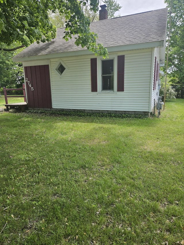 2745 Riverside Rd, Benton Harbor, MI 49022 - view of property exterior with a chimney, a shingled roof, and a yard
