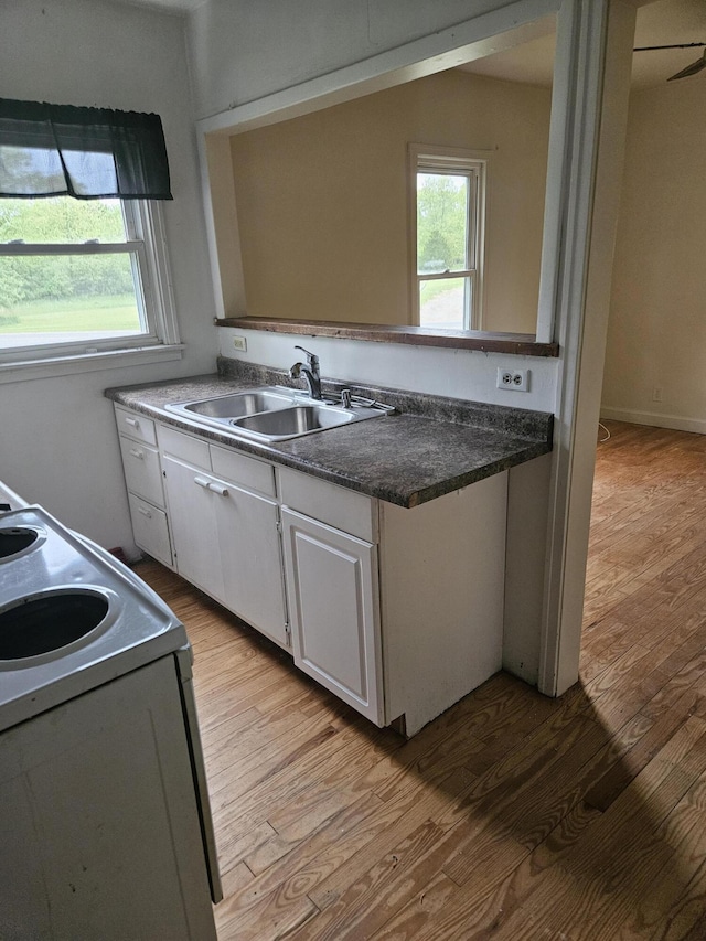 2745 Riverside Rd, Benton Harbor, MI 49022 - kitchen with a sink, light wood finished floors, and white cabinetry