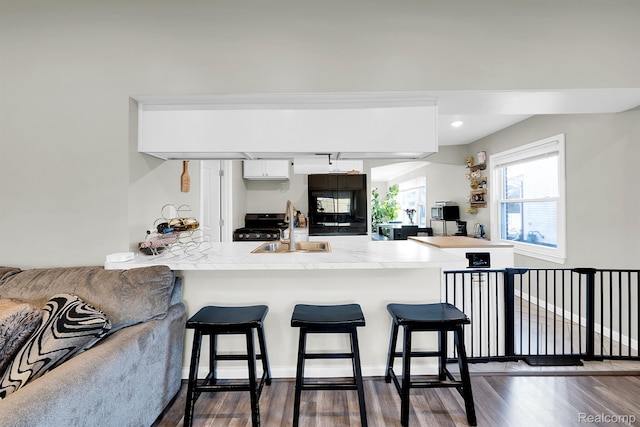 15487 Greydale St, Detroit, MI 48223 - kitchen featuring a sink, a peninsula, dark wood finished floors, a breakfast bar area, and recessed lighting