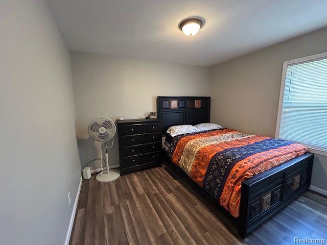 15487 Greydale St, Detroit, MI 48223 - bedroom with multiple windows, dark wood-style floors, and baseboards