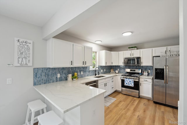 1011 Knowles St, Royal Oak, MI 48067 - kitchen with stainless steel appliances, light stone countertops, white cabinetry, a peninsula, and a sink