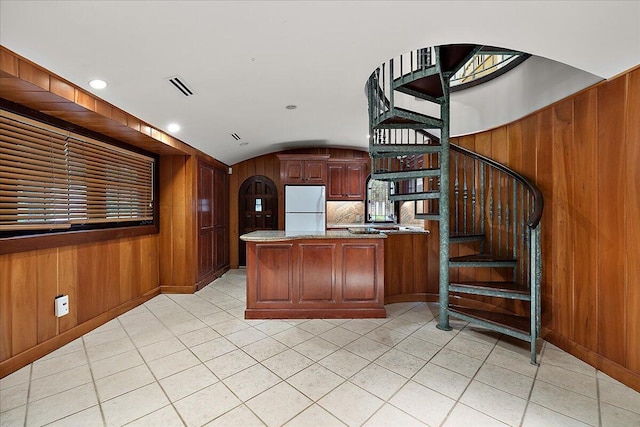 490 E Long Lake Rd, Bloomfield Hills, MI 48304 - kitchen featuring freestanding refrigerator, a peninsula, light tile patterned flooring, wooden walls, and lofted ceiling