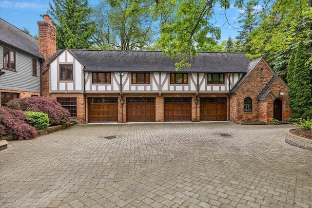 490 E Long Lake Rd, Bloomfield Hills, MI 48304 - tudor-style house with a garage, driveway, and brick siding
