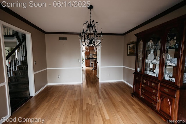 515 Oakbridge Dr, Rochester, MI 48306 - unfurnished dining area with a chandelier, hardwood / wood-style floors, stairs, and crown molding