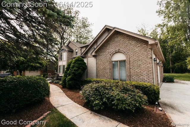 515 Oakbridge Dr, Rochester, MI 48306 - view of front facade featuring brick siding, a garage, and concrete driveway