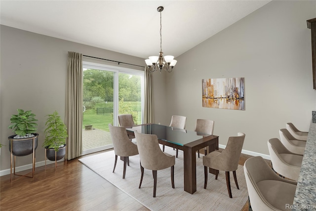 13135 River Rock Pass, Linden, MI 48451 - dining space featuring a chandelier, wood finished floors, vaulted ceiling, and baseboards