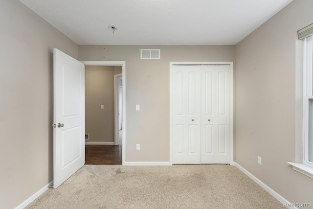 13135 River Rock Pass, Linden, MI 48451 - unfurnished bedroom featuring carpet, a closet, and baseboards