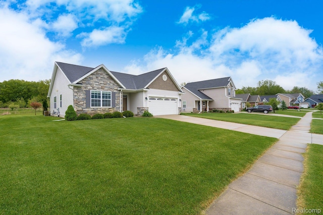 13135 River Rock Pass, Linden, MI 48451 - view of front facade with stone siding, a front yard, driveway, and a garage
