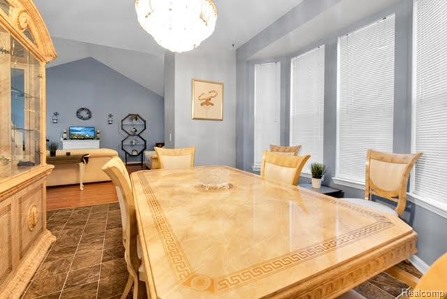 32051 W Cranston St, New Haven, MI 48048 - dining room featuring vaulted ceiling and a chandelier