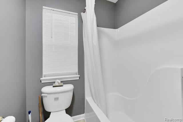 32051 W Cranston St, New Haven, MI 48048 - bathroom featuring toilet, shower / bath combo with shower curtain, and baseboards
