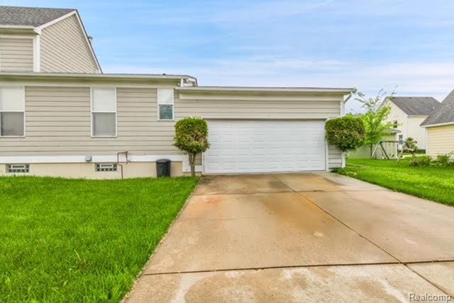 32051 W Cranston St, New Haven, MI 48048 - view of side of property with a yard, a garage, and concrete driveway