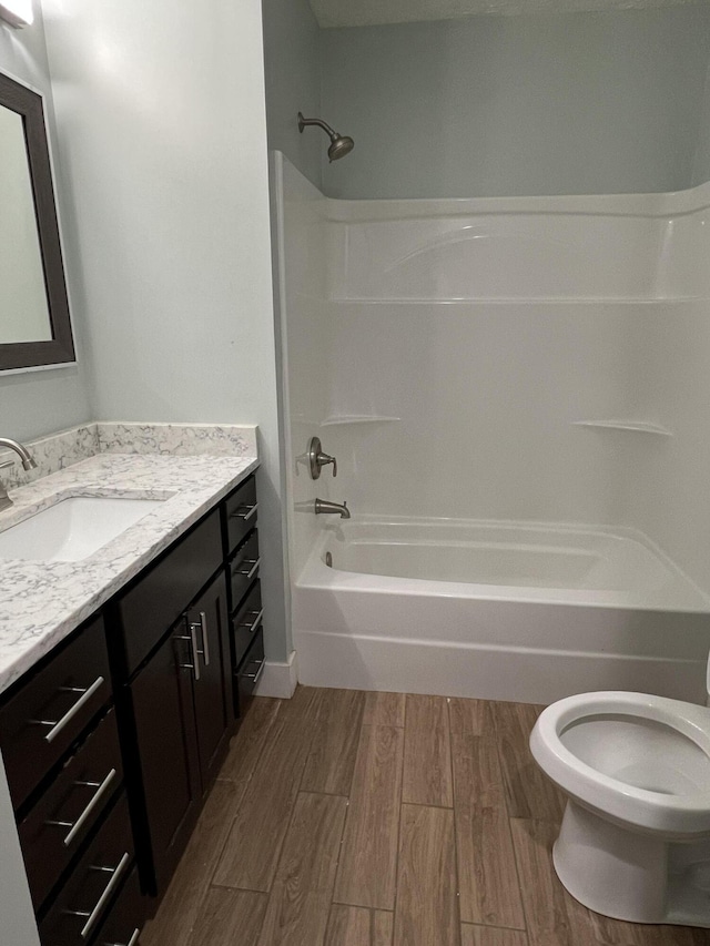 1302 Barnes St, Albion, MI 49224 - full bathroom featuring wood finished floors, vanity, bathtub / shower combination, and toilet