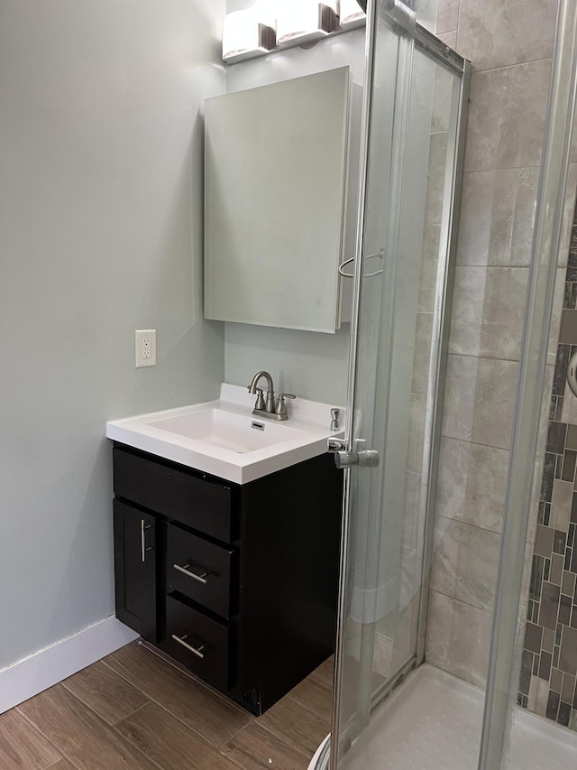 1302 Barnes St, Albion, MI 49224 - bathroom with vanity, a shower stall, wood finished floors, and baseboards