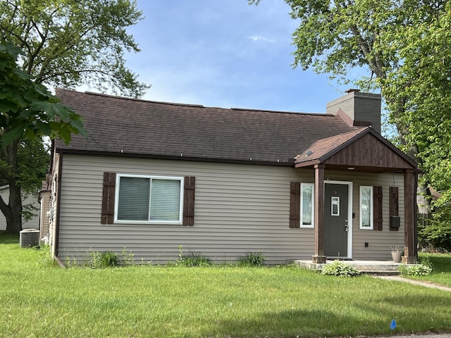 1302 Barnes St, Albion, MI 49224 - view of front facade featuring a shingled roof, cooling unit, a chimney, and a front yard
