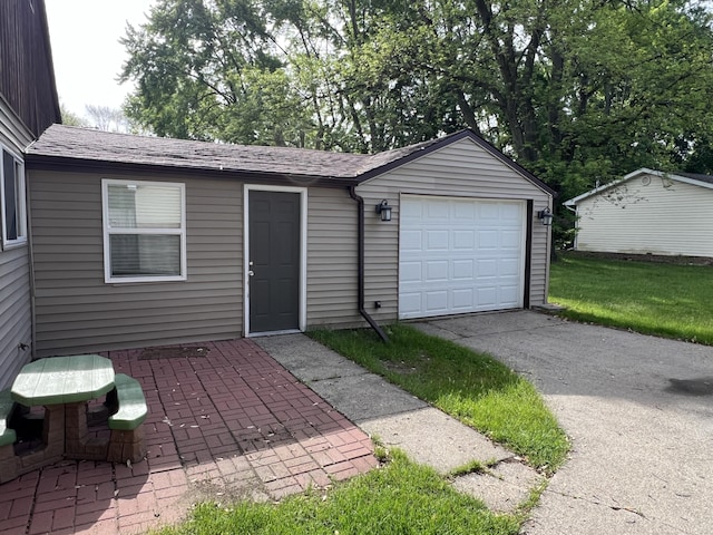 1302 Barnes St, Albion, MI 49224 - view of front of property featuring asphalt driveway, a garage, roof with shingles, and an outbuilding