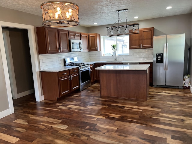 1302 Barnes St, Albion, MI 49224 - kitchen with appliances with stainless steel finishes, a textured ceiling, a sink, light countertops, and dark wood finished floors