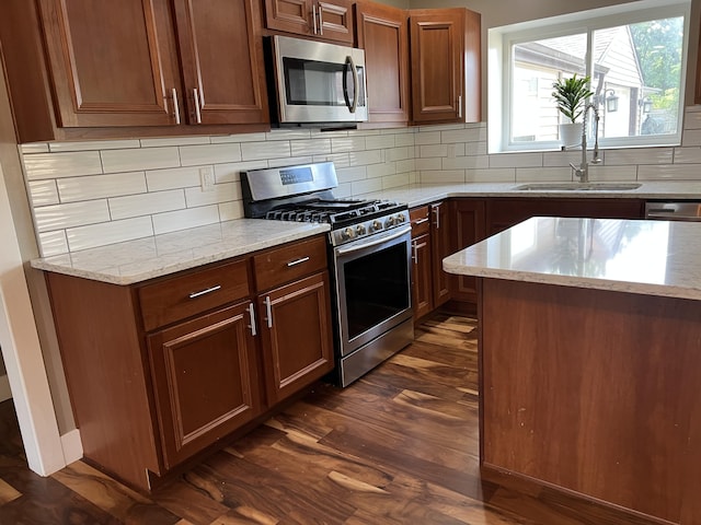 1302 Barnes St, Albion, MI 49224 - kitchen featuring appliances with stainless steel finishes, a sink, tasteful backsplash, light stone counters, and dark wood-style flooring