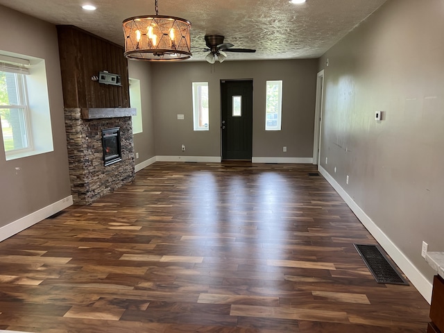 1302 Barnes St, Albion, MI 49224 - unfurnished living room featuring dark wood finished floors, baseboards, a ceiling fan, a stone fireplace, and recessed lighting