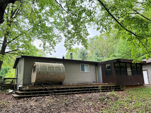 10750 16 Mile Rd NE, Cedar Springs, MI 49319 - rear view of property featuring a wooden deck and a sunroom