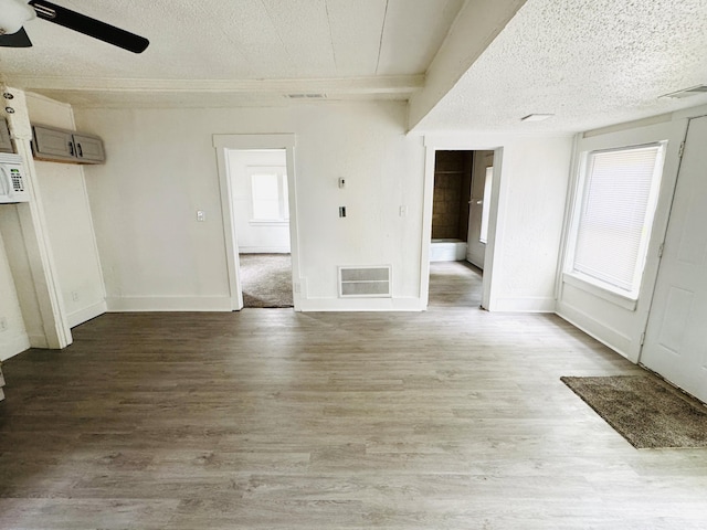 2513 5th St, Muskegon, MI 49444 - empty room featuring a ceiling fan, wood finished floors, a textured ceiling, plenty of natural light, and baseboards