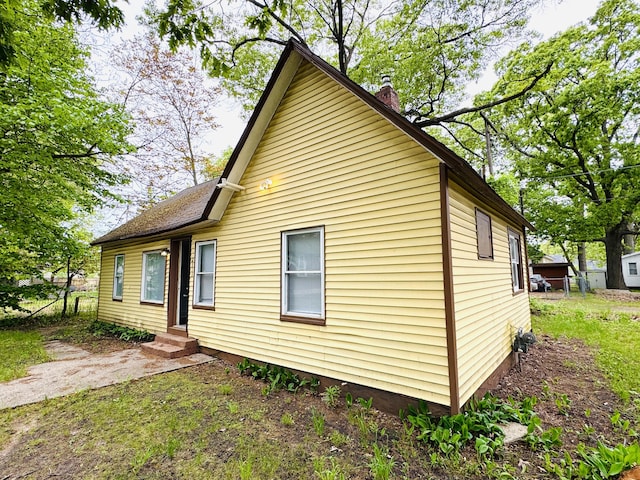 2513 5th St, Muskegon, MI 49444 - view of side of property with a chimney and entry steps