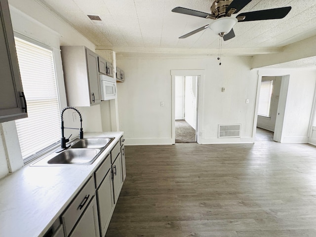 2513 5th St, Muskegon, MI 49444 - kitchen with a sink, gray cabinetry, ceiling fan, light countertops, and dark wood finished floors