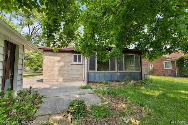 3183 Mildred St, Wayne, MI 48184 - view of front of home featuring a sunroom, brick siding, and a front lawn
