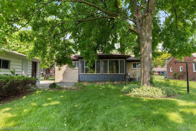 3183 Mildred St, Wayne, MI 48184 - back of property with brick siding, a yard, and a sunroom
