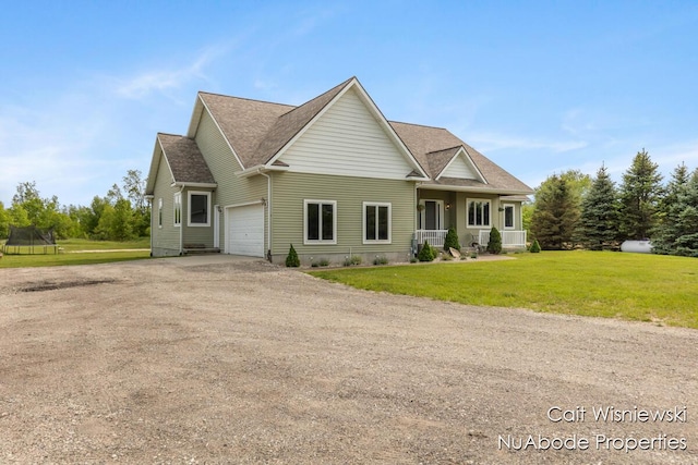 3732 E 128th St, Grant, MI 49327 - view of front of home with driveway, a trampoline, a garage, and a front yard