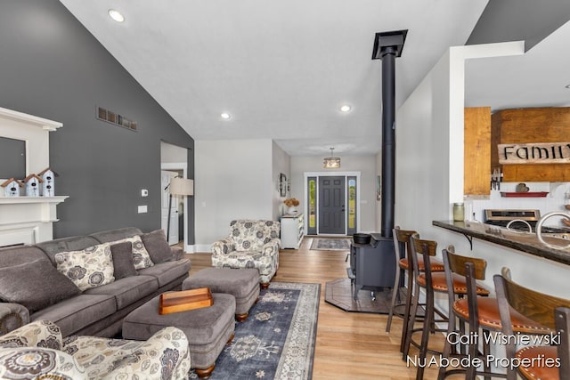 3732 E 128th St, Grant, MI 49327 - living area with a wood stove, light wood-style floors, recessed lighting, and high vaulted ceiling