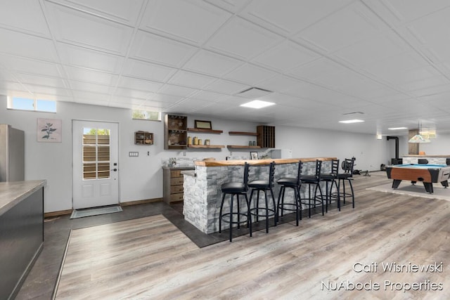 3732 E 128th St, Grant, MI 49327 - kitchen featuring refrigerator, light wood finished floors, open shelves, billiards, and a kitchen bar