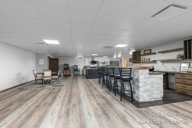 3732 E 128th St, Grant, MI 49327 - kitchen with open shelves, wood finished floors, stainless steel appliances, a kitchen bar, and a center island