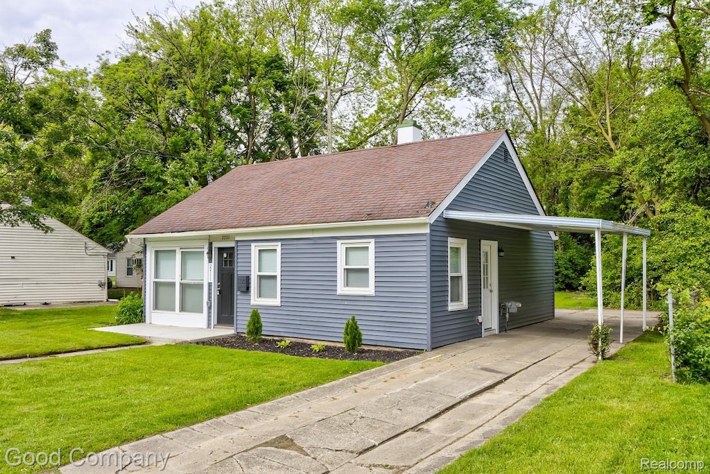 22111 Condon St, Oak Park, MI 48237 - view of front facade featuring driveway, a front lawn, an attached carport, a chimney, and roof with shingles