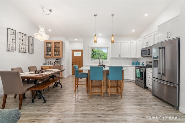 1200 Iroquois Trl, Hastings, MI 49058 - kitchen featuring stainless steel appliances, light countertops, vaulted ceiling, light wood-type flooring, and a kitchen island